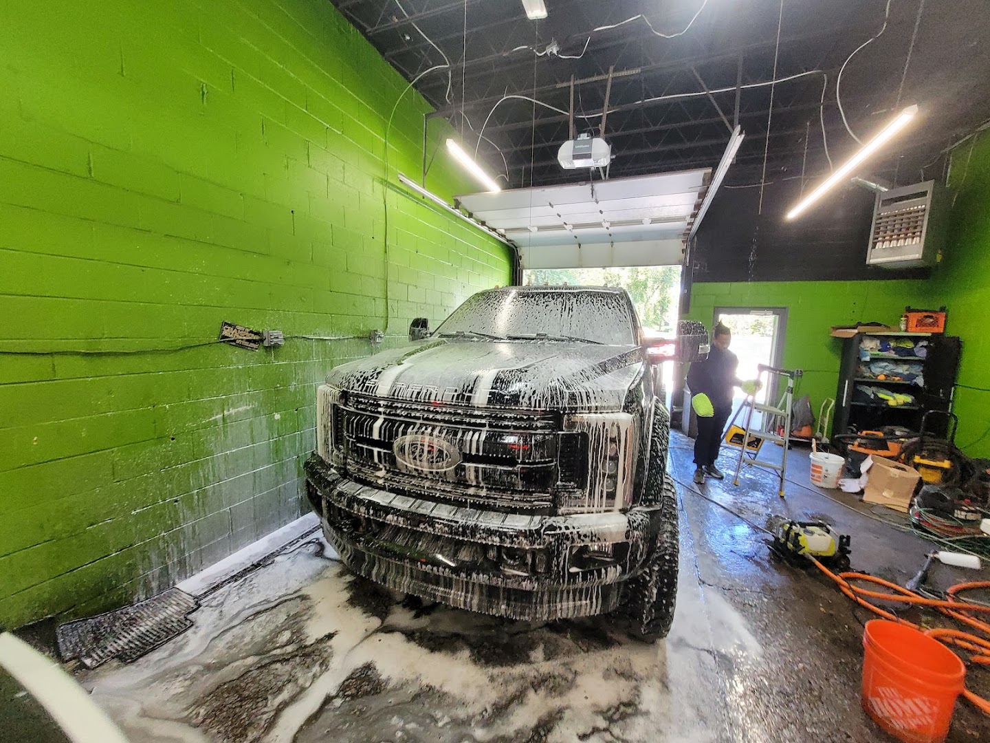 Large SUV covered in soap foam being hand-washed at DA Wash