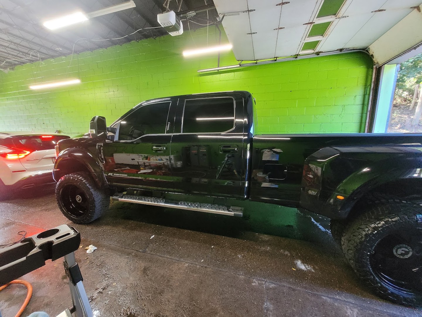 Black lifted Ford truck with mirror shine after hand wash service
